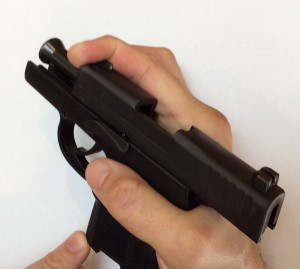 Sig P290 Field Stripping Instructions, Step 1: Pull the slide back with your index finger hooked around the end. Look for the slot in the slide to line up with the take down lever.